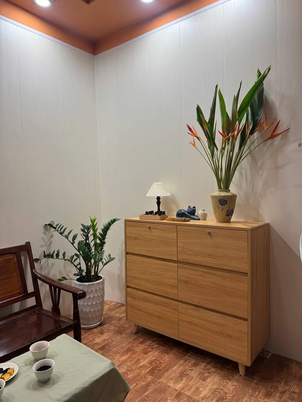 Góc tiếp đón thật tại AnRohi với bàn trà, tủ gỗ và hoa thiên điểu